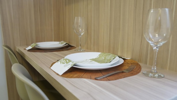 A neatly set dining table with plates, cutlery, and wine glasses, suggesting a formal dining experience. - 5 Minutes From Copacabana Beach Nsc1109 (Rio de Janeiro)