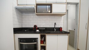 A compact kitchen with a built-in microwave, oven, and sink. - 5 Minutes From Copacabana Beach Nsc1109 (Rio de Janeiro)