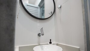 A modern bathroom with a white sink, a round mirror, and a faucet. - 5 Minutes From Copacabana Beach Nsc1109 (Rio de Janeiro)