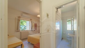 Ein Schlafzimmer mit einem Bett, einem Fenster und einer Klimaanlage.