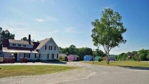 Een woonstraat met huizen, een heldere lucht en een kruispunt.