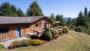 A wooden house with a blue door, a porch, and a well-maintained garden. - ☀️🌲Falcons Perch: Nature Lover's Dream, in coastal hills above Blue Lake🪶 (Mckinleyville)