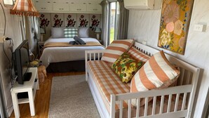 A cozy bedroom with two beds, a TV, and a small table.
