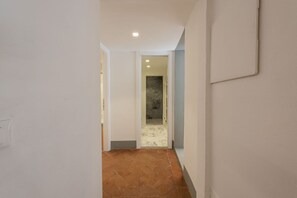 A hallway with a tiled floor leading to a bathroom with a marble floor. - Santo Spirito View in Florence by Mmega (Firenze)