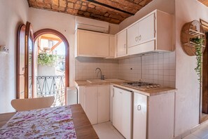 Une cuisine de taille réduite, avec des meubles blancs, un évier et une cuisinière.