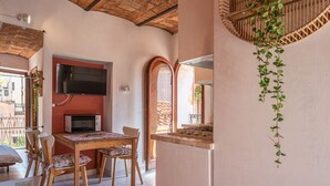 Ein Essbereich mit Holztisch und Stühlen, einem Fernseher und einer Mikrowelle.