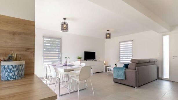 A spacious living area with a dining table, chairs, a sofa, and a TV. - Vacation home Vinci by Interhome (Royan)