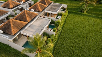 Una villa moderna con varias habitaciones, piscina y un paisaje verde exuberante.