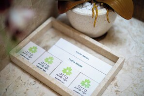 Un plateau contenant divers articles de toilette, notamment une brosse à dents, un sac d’hygiène et un bonnet de douche.