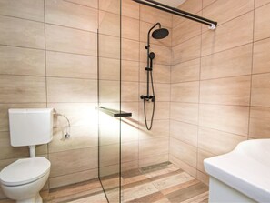 A modern bathroom with a glass-enclosed shower, a toilet, and a bathtub. - Vacation home Aurora by Interhome (Skradin)