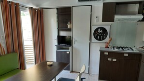 Eine kleine Küchenzeile mit Gasherd, einem kleinen Kühlschrank und einem Fernseher.