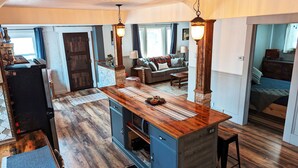 A spacious kitchen with a wooden island, a dining area, and a living room with a sofa and a coffee table. - Enjoy relaxing comfort in this uniquely designed home - 5min from Frontier Park (Cheyenne)