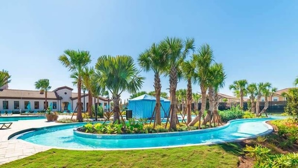 A resort with a swimming pool, palm trees, and a blue tent. - Stunning Lake View! Themed Bedrooms With Comfortable and Sophisticated Decor (Kissimmee)