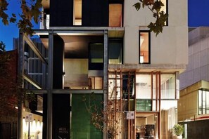 A modern hotel with a glass facade, multiple floors, and a visible entrance. - Alex Hotel (Northbridge)