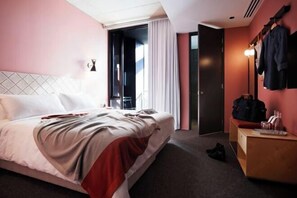 A hotel room with a bed, a bedside table, a mirror, a wardrobe, and a door leading to a balcony. - Alex Hotel (Northbridge)