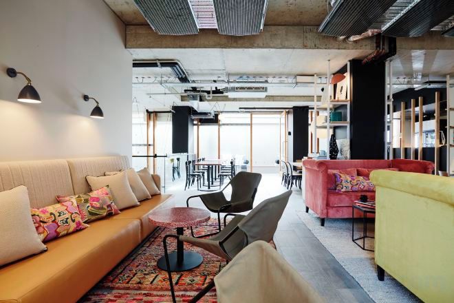 A modern lounge area with a sofa, chairs, and a small table.