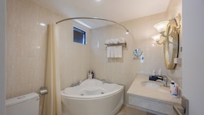 Une salle de bain moderne avec une baignoire sur pieds, un lavabo, un miroir et des toilettes.