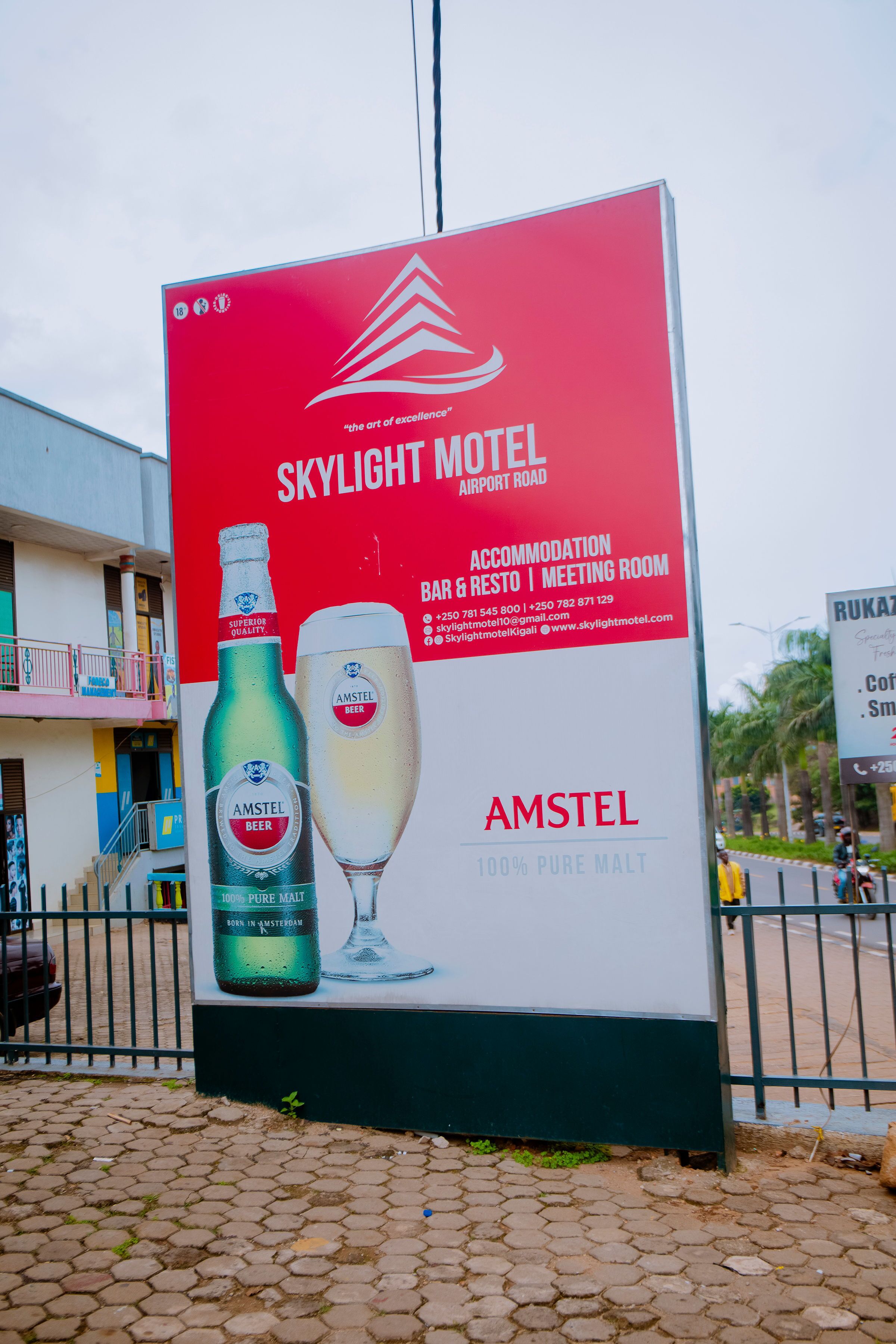 A billboard for Skylight Motel advertising Amstel beer, with contact information and amenities listed.