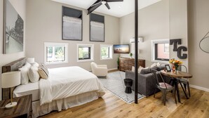 Une chambre moderne avec un grand lit, un bureau, une chaise, un canapé et un téléviseur.