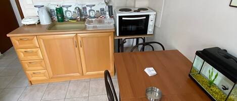 Réfrigérateur, un four, bouilloire électrique, vaisselle et ustensiles