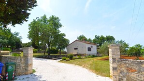 A house with a stone wall entrance, a gravel driveway, and a well-maintained lawn. - House 2174/55597 (Istria - Rovinj), 600m from the beach (Rovinj)