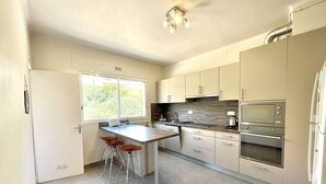 A modern kitchen with a central island, stainless steel appliances, and a large window providing natural light. - 3-room apartment, 2 bedrooms, sleeps 4 in Ajaccio (Ajaccio)
