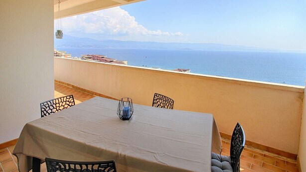 A balcony with a table and chairs, overlooking a coastal view. - 3-room apartment, 2 bedrooms, sleeps 4 in Ajaccio (Ajaccio)