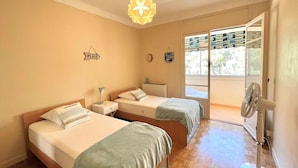 A hotel room with two beds, a ceiling fan, a window with a view, and a sign on the wall. - 3-room apartment, 2 bedrooms, sleeps 4 in Ajaccio (Ajaccio)