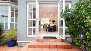 Ein modernes Haus mit einem geräumigen Essbereich, einer Küche und einem großen Fenster.