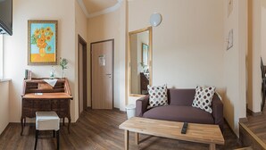 A living room with a sofa, a coffee table, a wooden cabinet, a mirror, and a painting on the wall. - 7 Zwerge Übernachtungspension (Lohr am Main)