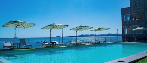 Piscine extérieure, parasols de plage, chaises longues