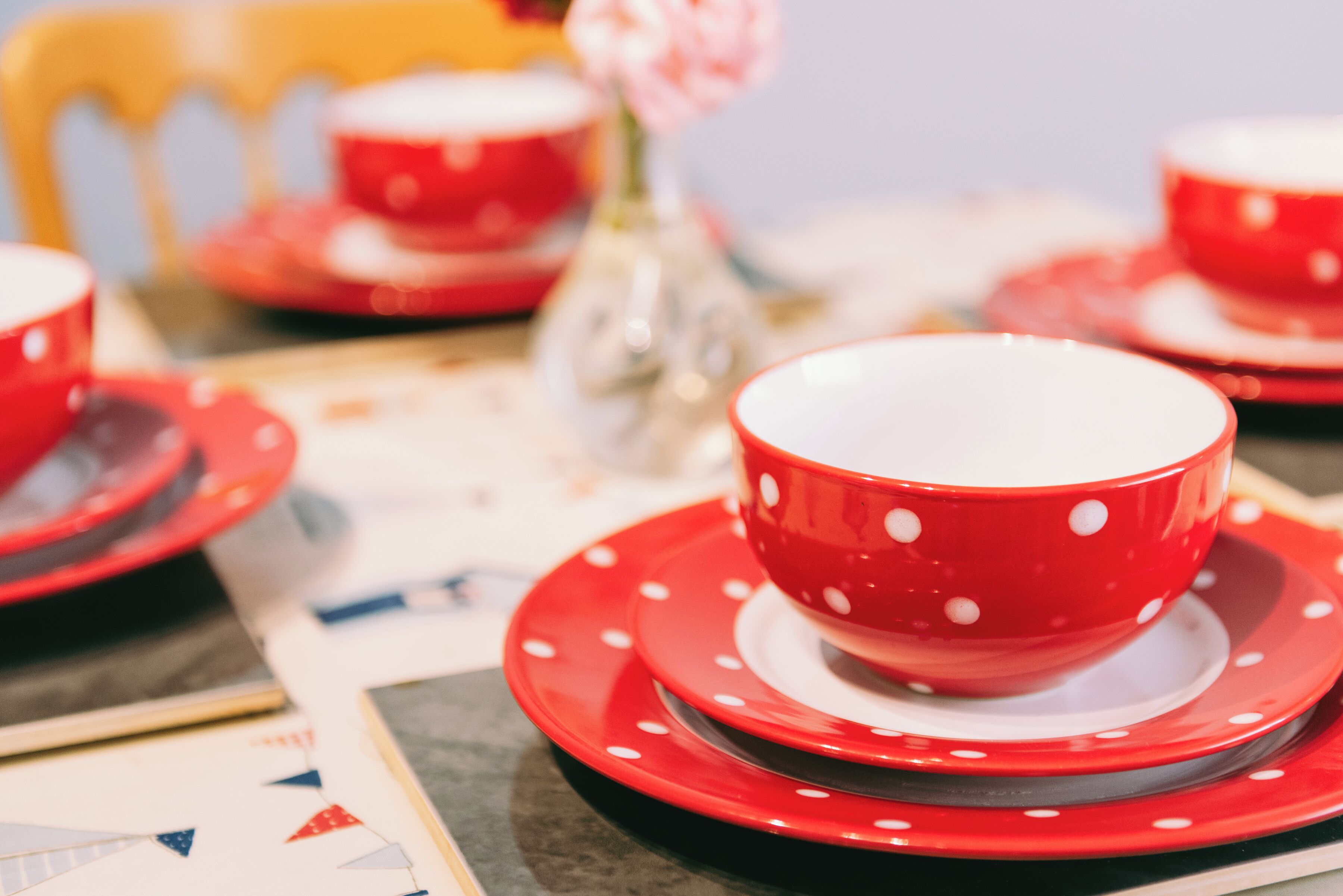 A table set with red and white polka-dotted tableware, including bowls and plates.