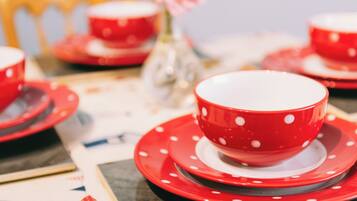 A table set with red and white polka-dotted tableware, including bowls and plates.