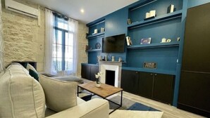 Ein Wohnzimmer mit Sofa, Couchtisch, Kamin und Einbauschränken mit Dekoration.