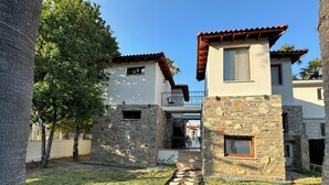 A courtyard with a stone pathway leading to a building with a balcony. - Villa Merry - Dalyan Stonehouse with Palmtrees (Muğla)