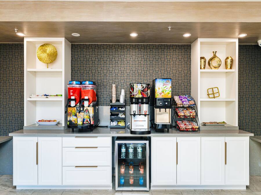 A self-service beverage station with various drink dispensers, a refrigerated drink cooler, and snack dispensers.