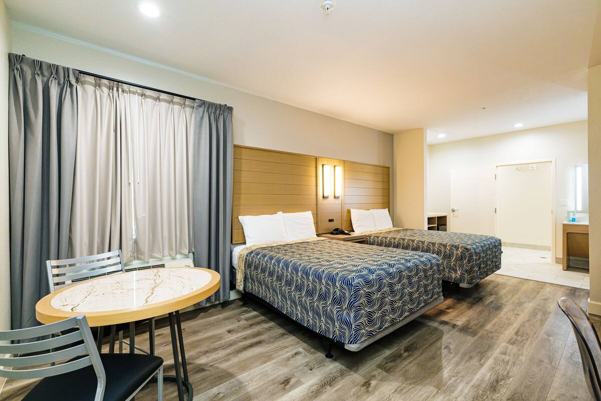 A hotel room with a bed, a desk, and a chair.