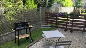 A patio area with a barbecue grill, a table, and a bench. - Downtown studio*** with outdoor parking and private, secure bike storage. (Bagnères-de-Bigorre)
