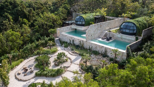 A modern villa with a swimming pool, surrounded by lush greenery and a pebble path. - Airship Bali by Alex Villas (Pecatu)