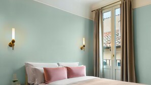 A hotel room with a bed, bedside tables, and a window with curtains. - Numa Rome Portico (Rome)