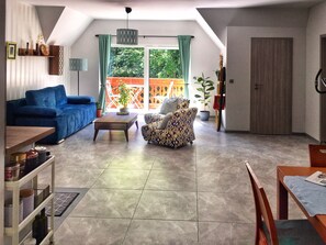 Relax in this inviting living area with a sofa, armchair, and dining table.