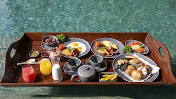 Un vassoio di legno con diversi articoli per la colazione, tra cui uova, pane tostato, frutta e bevande.