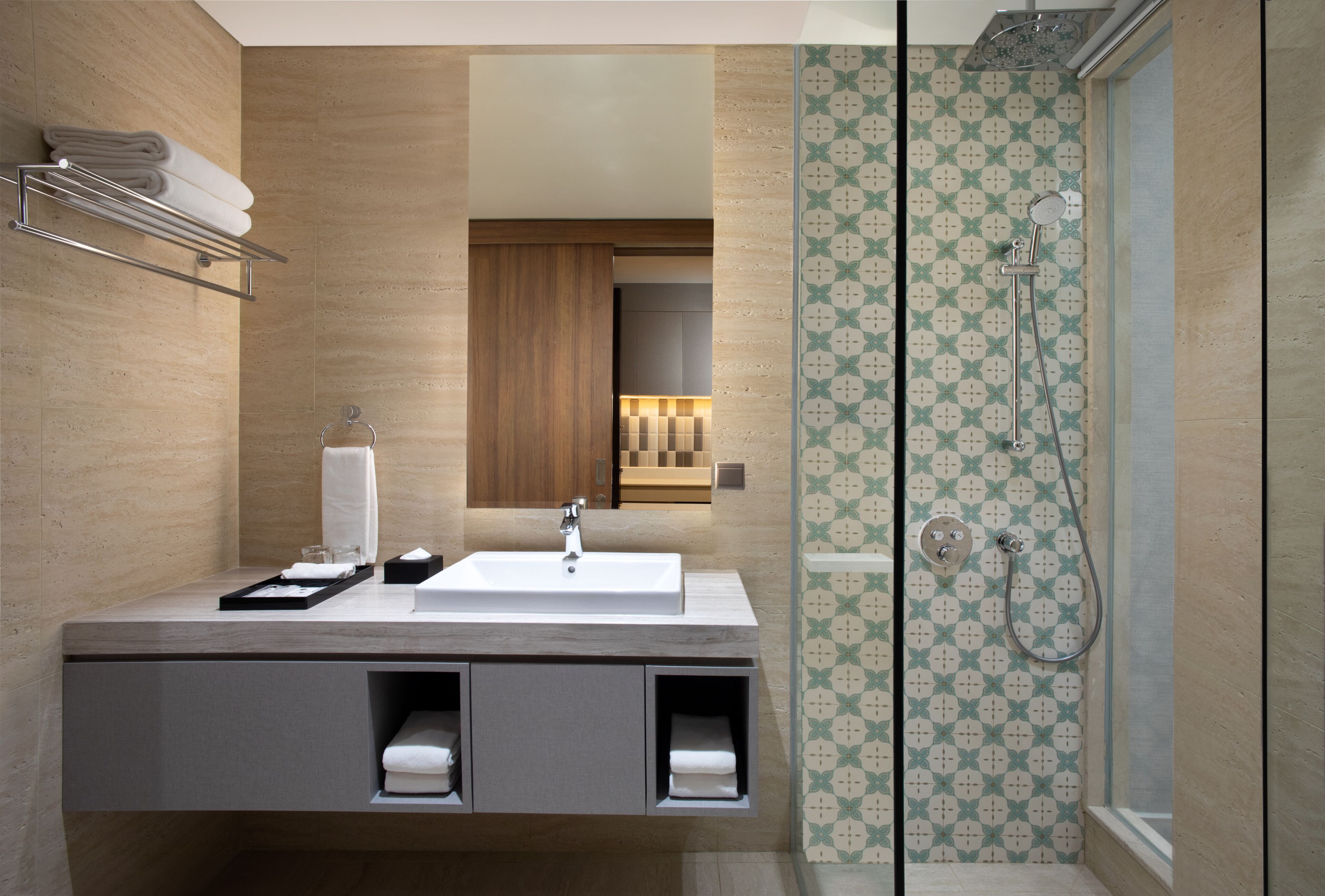 Een moderne badkamer met een wastafel, handdoekhouder en douche.