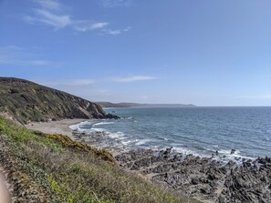 A coastal landscape with rocky terrain and a beach.