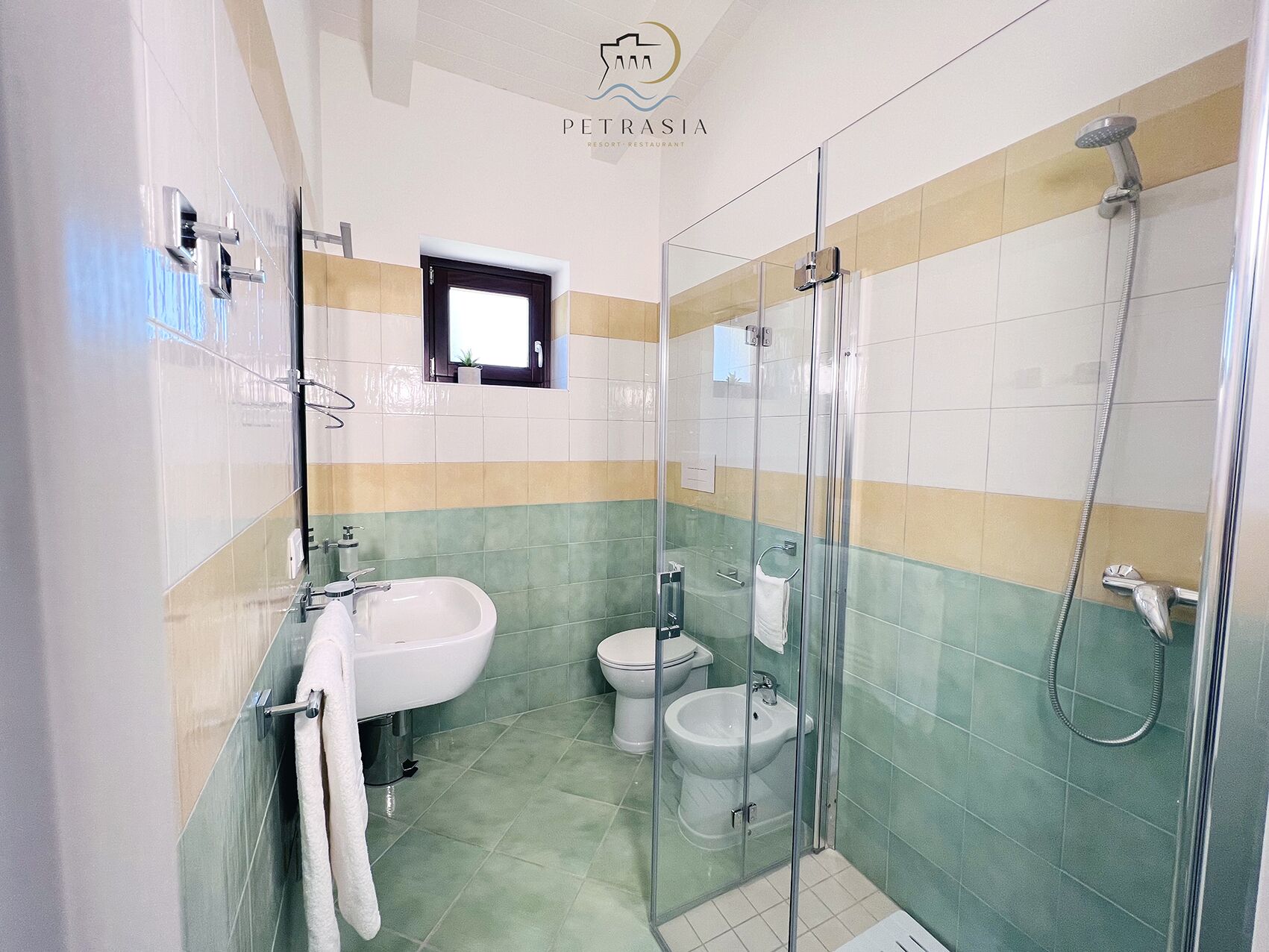 Een badkamer met een wastafel, toilet, bidet en douchecabine.