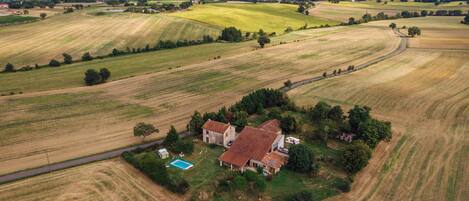 Vista aèria d'una finca rural amb camps, una casa i una piscina.