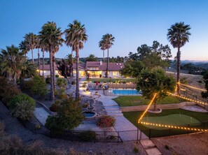 A residential property with a swimming pool, outdoor seating, and a well-maintained garden. - Luxe Ranch w/360 Degree Views, Pool, Gym, Game Room and Acres of Fun for All (Templeton)