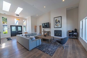 A spacious living area with a sofa, coffee table, and a fireplace.
