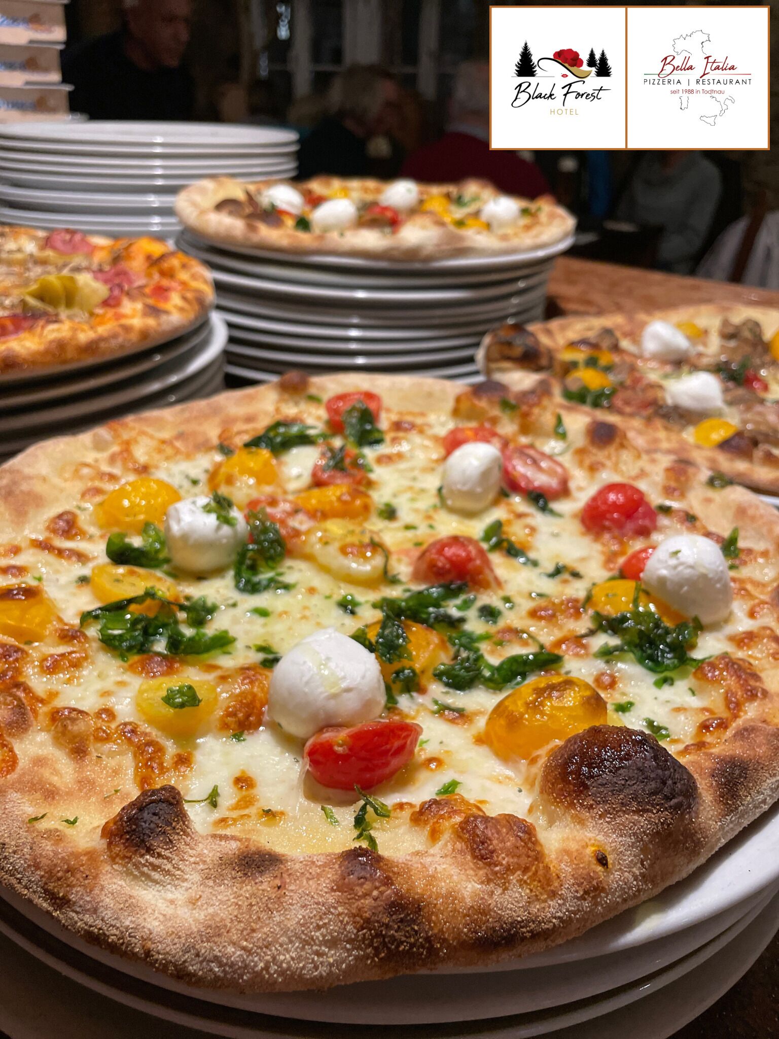 A pizza with various toppings and a logo for Bella Italia Pizzeria | Restaurant in the top right corner.