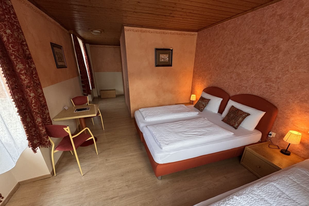 Una habitación de hotel con dos camas, un escritorio y una silla.